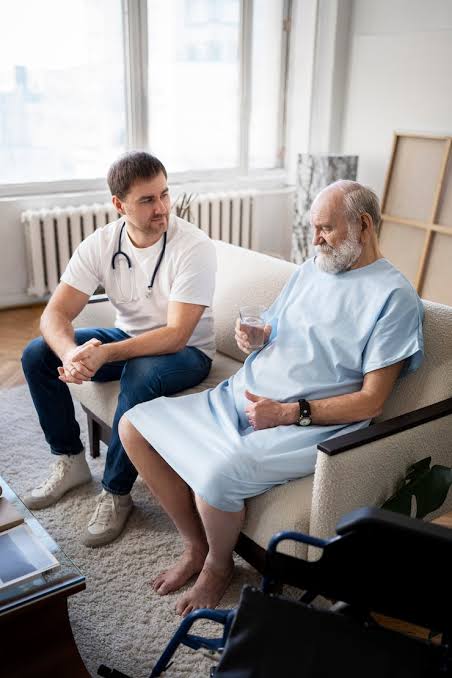 A caregiver checking in with an elderly patient at home